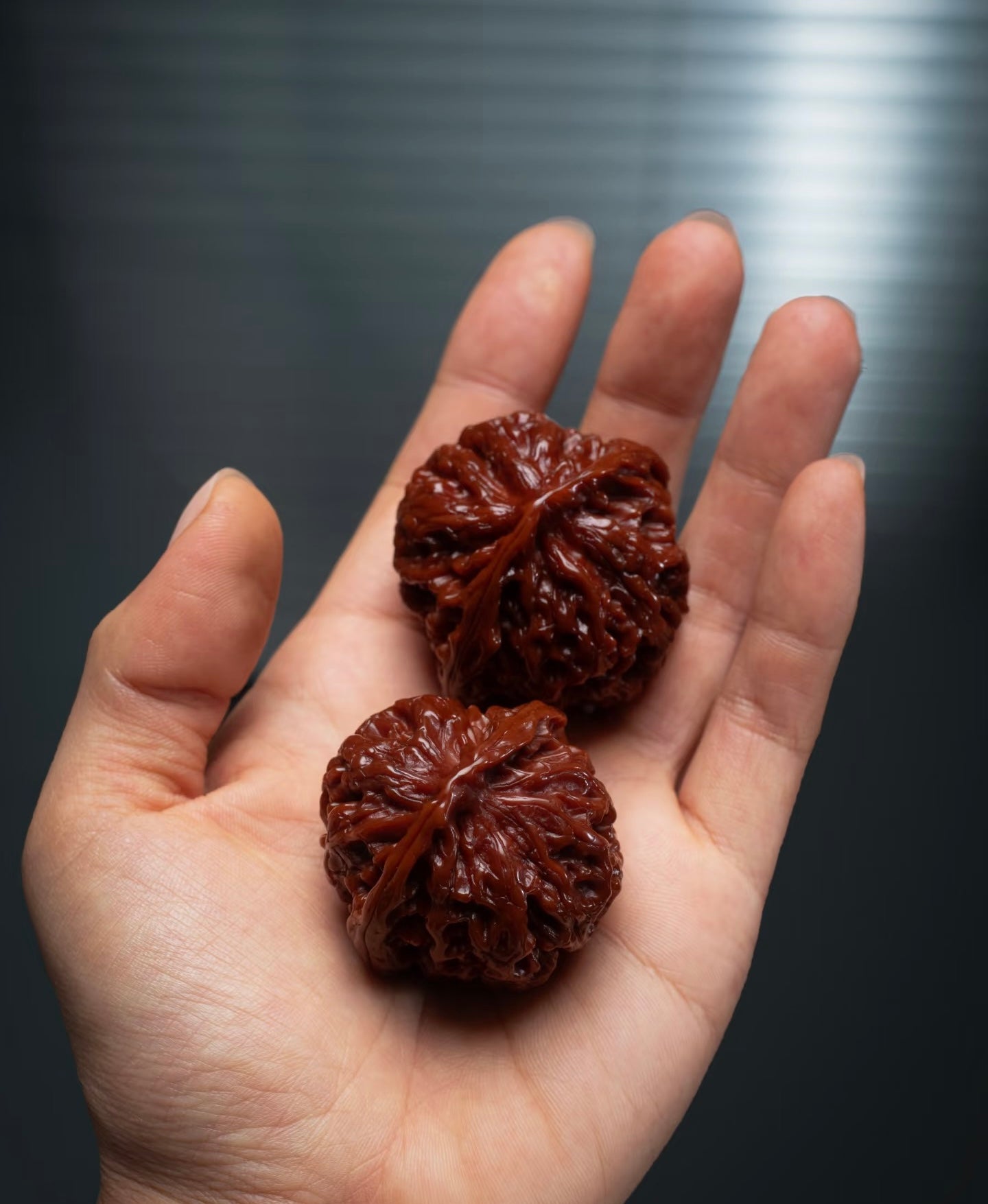A pair of handled walnuts sitting in an open hand